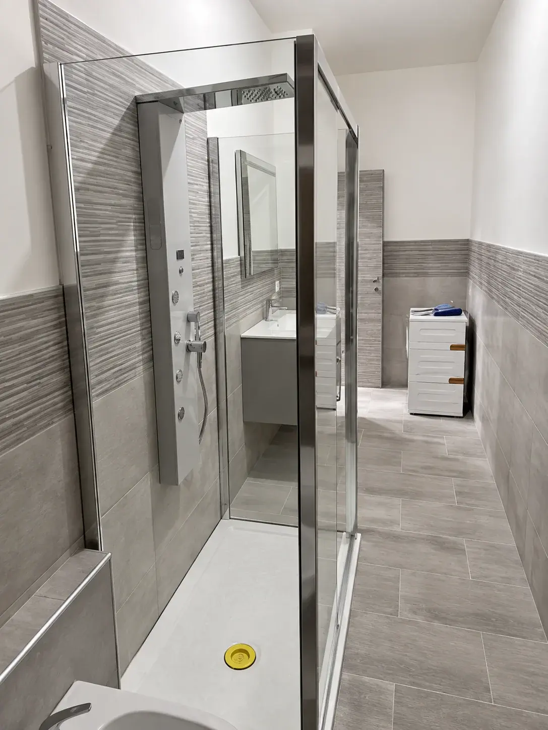 Box doccia in vetro con colonna doccia e rivestimenti a rilievo
