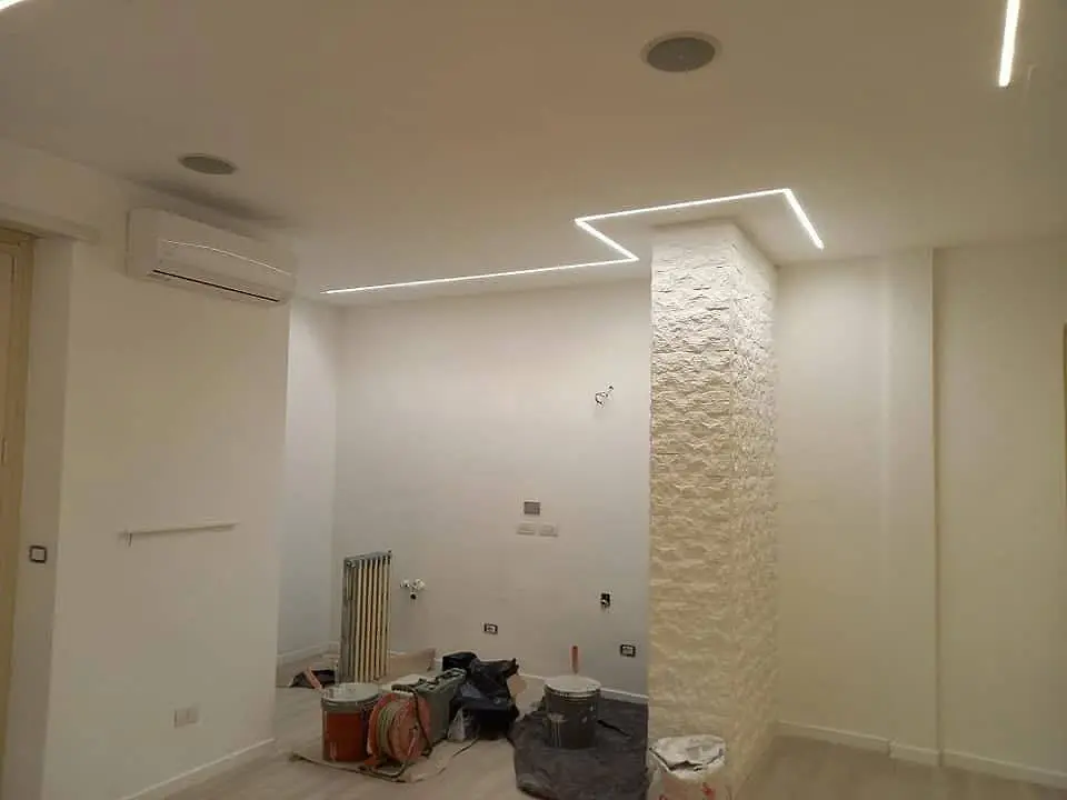 Interno con parete a effetto pietra illuminata